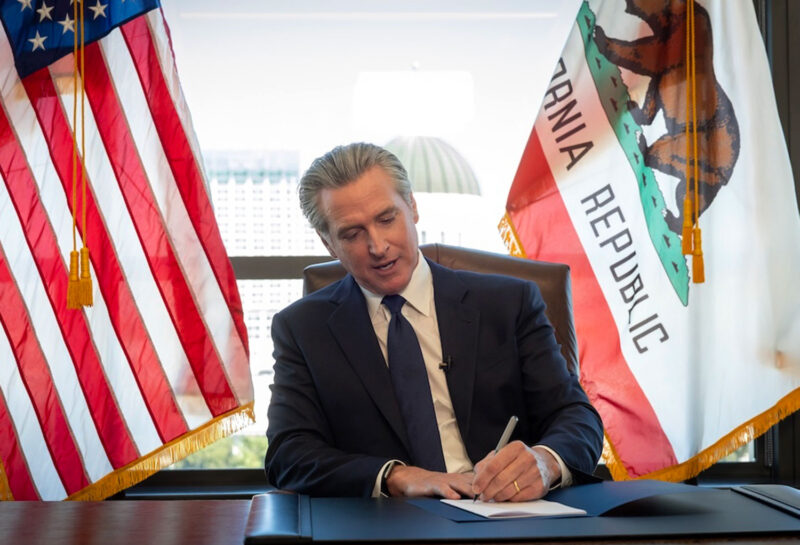 Gov. Newsom signed the legislation in his office surrounded by members of the Capitol Press Corps.